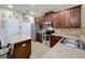 Open kitchen featuring an island, stainless appliances and brown cabinets at 3620 Chandler Estates Dr, Apopka, FL 32712
