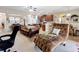 Open concept living room featuring plush seating, ceiling fan, and kitchen bar at 3620 Chandler Estates Dr, Apopka, FL 32712