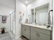 Bathroom featuring dual sinks, stone countertops, and a glass-enclosed shower at 3764 Shoveler Ave, Leesburg, FL 34748