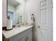 Bathroom with a large mirror, gray cabinets, granite countertop, and white door at 3764 Shoveler Ave, Leesburg, FL 34748