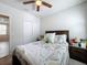 Inviting bedroom with a bed dressed in patterned bedding, side tables, and a view into the bathroom at 3764 Shoveler Ave, Leesburg, FL 34748