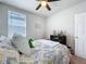 Bright bedroom featuring a ceiling fan and a patterned bedspread at 3764 Shoveler Ave, Leesburg, FL 34748