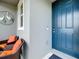 Home exterior featuring a blue front door, outdoor seating, and decorative heron wall art at 3764 Shoveler Ave, Leesburg, FL 34748