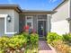 Inviting front porch featuring a decorative screen door, lush landscaping, and a cozy seating area at 3764 Shoveler Ave, Leesburg, FL 34748