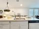 Kitchen island features a stainless steel sink, granite countertop, and sleek, modern cabinetry at 3764 Shoveler Ave, Leesburg, FL 34748