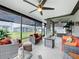 Screened-in patio with comfortable wicker furniture, ceiling fans, and views of the backyard at 3764 Shoveler Ave, Leesburg, FL 34748