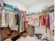 Spacious walk-in closet with ample hanging space, shelving, and a cozy seating area at 3764 Shoveler Ave, Leesburg, FL 34748