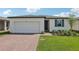 Inviting single-story home with a two-car garage, brick driveway, and lush green lawn at 3872 Giorgio Dr, Winter Haven, FL 33884
