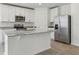 Bright kitchen features white cabinets, stainless steel appliances, and a large island with granite countertops at 3872 Giorgio Dr, Winter Haven, FL 33884