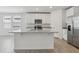 Bright kitchen features white cabinets, stainless steel appliances, and a large island with granite countertops at 3872 Giorgio Dr, Winter Haven, FL 33884