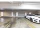 Brightly lit parking garage spot featuring a white Jaguar with red accents and striped racing stripes on the hood at 401 E Robinson St # 202, Orlando, FL 32801