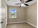 This cozy bedroom features neutral walls, wood-look tile floors, and a ceiling fan at 4207 Chateau Rd, Orlando, FL 32808