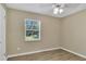 A serene bedroom with neutral walls, wood-look tile floors, and a bright window at 4207 Chateau Rd, Orlando, FL 32808