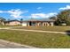 Charming single-story home with well-maintained lawn and attached one car garage, under a bright blue sky at 4207 Chateau Rd, Orlando, FL 32808