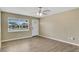 Bright, empty living room featuring wood floors, neutral walls, ceiling fan, and a window at 4207 Chateau Rd, Orlando, FL 32808