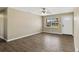 Empty living room with wood floors, neutral walls, ceiling fan, and a window at 4207 Chateau Rd, Orlando, FL 32808