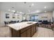 Open-concept kitchen with island, pendant lighting, stainless appliances, dining area and living room at 4353 Lana Ave, Davenport, FL 33897