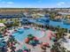 Aerial view of the community pool area, featuring ample seating, vibrant umbrellas, and swaying palm trees at 4353 Lana Ave, Davenport, FL 33897