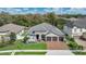 An aerial view of a single-Gathering home featuring manicured lawn and a three-car garage at 4419 Liberty Bell Cv, Orlando, FL 32817