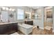 Elegant bathroom showcasing a freestanding tub, dark wood cabinets, granite counters, and a glass-enclosed shower at 4419 Liberty Bell Cv, Orlando, FL 32817