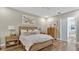 Comfortable bedroom with wood-look floors, a wooden bed frame, a large art piece, and access to the bathroom at 4419 Liberty Bell Cv, Orlando, FL 32817