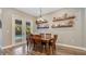 Inviting dining room featuring wood floors, a dining set, decorative wall shelves, and sliding doors leading to the lanai at 4419 Liberty Bell Cv, Orlando, FL 32817