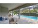 Relaxing screened-in pool area with comfortable seating, tiled floors, a pool, a spa, and well-manicured landscaping at 4419 Liberty Bell Cv, Orlando, FL 32817