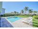 Backyard pool with lounge chairs surrounded by lush landscaping and a well-maintained lawn in a relaxing setting at 480 Burma St, Kissimmee, FL 34747