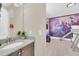 Bathroom with granite counters and an adjacent themed bedroom with custom bunk beds, and Marvel mural at 480 Burma St, Kissimmee, FL 34747
