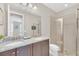 Bathroom featuring a double vanity, a framed mirror, and a glass door shower stall at 480 Burma St, Kissimmee, FL 34747