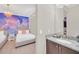 Themed bedroom featuring an elegant chandelier, themed wall art, and a connecting vanity in the en suite bathroom at 480 Burma St, Kissimmee, FL 34747