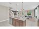 Open kitchen with a large island, stainless steel appliances, and a view of the dining and living areas at 480 Burma St, Kissimmee, FL 34747