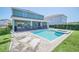 Sparkling pool with integrated spa, covered patio and sun loungers in a green backyard at 480 Burma St, Kissimmee, FL 34747