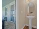 Powder room with a pedestal sink and modern fixtures, conveniently located off the covered outdoor living space at 480 Burma St, Kissimmee, FL 34747