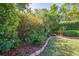 Landscaped backyard featuring lush greenery, mulch beds, and a well-maintained brick border at 4933 Raylene Way, St Cloud, FL 34771