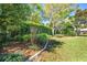 Backyard featuring decorative landscaping, manicured lawn, and a brick-lined flower bed, adding charm at 4933 Raylene Way, St Cloud, FL 34771