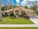 Charming single-story home featuring a manicured lawn, mature landscaping, and an attached two-car garage at 4933 Raylene Way, St Cloud, FL 34771