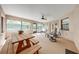Enclosed patio featuring a ceiling fan, dining table, and comfortable seating with views of the lush surroundings at 4933 Raylene Way, St Cloud, FL 34771