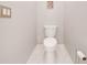 Modern powder room with a toilet and a clean, minimalist design and white tile flooring at 4933 Raylene Way, St Cloud, FL 34771