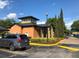 Exterior view of community clubhouse with lush landscaping and convenient parking at 5959 Westgate Dr # 1526, Orlando, FL 32835