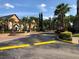 Community entrance with gated access, a fountain, and landscaping with mature palm trees and lush greenery at 5959 Westgate Dr # 1526, Orlando, FL 32835