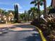 Community entrance featuring gated access, mature palm trees, and well-maintained landscaping at 5959 Westgate Dr # 1526, Orlando, FL 32835