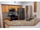 The kitchen is shown with wood cabinets, granite counters, and stainless steel appliances at 5959 Westgate Dr # 1526, Orlando, FL 32835