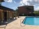 Community pool with tiled deck, chaise lounges, palm trees, and manicured hedges in a shared outdoor space at 5959 Westgate Dr # 1526, Orlando, FL 32835