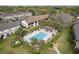 Aerial view of a community pool with ample lounge chairs, an outdoor bar, and mature landscaping at 600 Northern Way # 502, Winter Springs, FL 32708