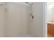 Tiled shower with adjustable shower head and a glimpse of the sink vanity and laminate floors at 600 Northern Way # 502, Winter Springs, FL 32708