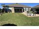 Backyard featuring a stone patio with outdoor seating, grass, and awning at 6832 Sw 93Rd Ave, Ocala, FL 34481