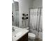 Bathroom with decorative shower curtain, dark wood shelves, and modern sink at 6832 Sw 93Rd Ave, Ocala, FL 34481