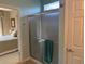 Bathroom featuring a glass door shower, view of bedroom, and an adjacent door at 6832 Sw 93Rd Ave, Ocala, FL 34481