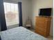 Bedroom featuring a comfortable bed, large window, and a dresser with a TV on top at 6832 Sw 93Rd Ave, Ocala, FL 34481